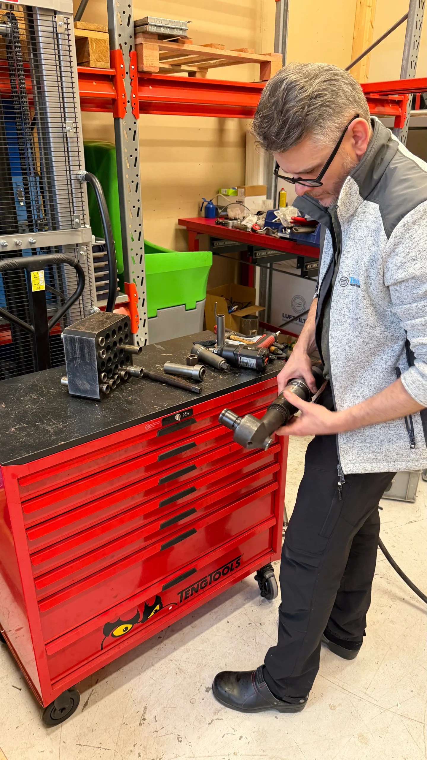 Operatör hanterar tubinvalsmaskin K77 vinkelvalsmaskin för invalsning av stora tubdimensioner i verkstad.